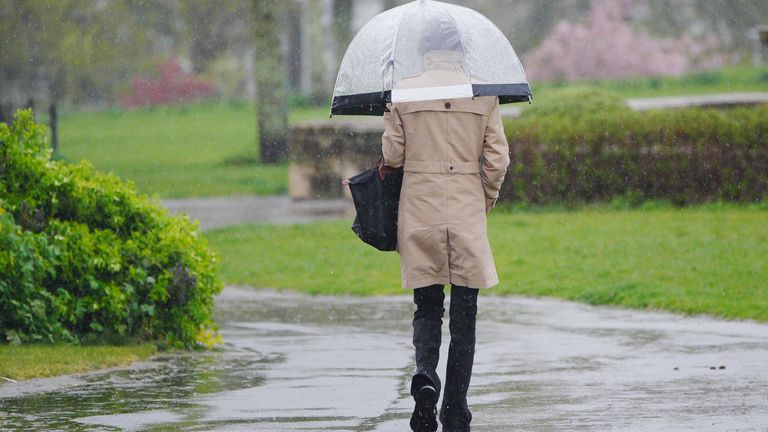 People walking in the heavy rain at Plymouth Hoe.
Pic: PA
